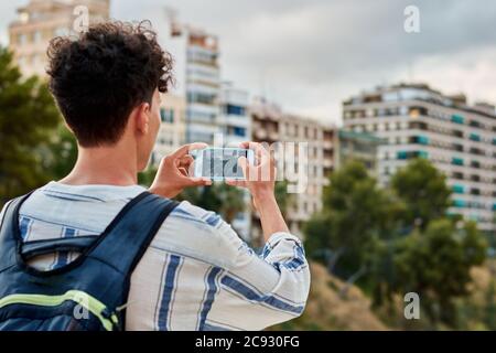 Nahaufnahme eines jungen afrohaarigen Mannes macht ein Foto Mit seinem Handy Stockfoto