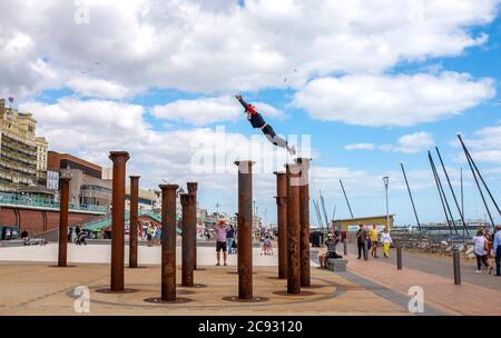 Brighton UK 28. Juli 2020 - EIN Freerunner springt an einem hellen und sonnigen, aber luftigen Tag über die Golden Spiral Pillars an der Küste von Brighton. Das Wetter wird in den nächsten Tagen im Südosten heiß, mit Temperaturen, die in einigen Gebieten über 30 Grad erreichen werden: Credit Simon Dack / Alamy Live News Stockfoto
