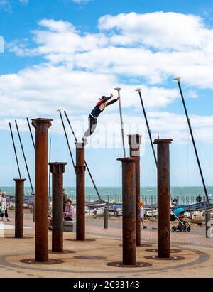 Brighton UK 28. Juli 2020 - EIN Freerunner springt an einem hellen und sonnigen, aber luftigen Tag über die Golden Spiral Pillars an der Küste von Brighton. Das Wetter wird in den nächsten Tagen im Südosten heiß, mit Temperaturen, die in einigen Gebieten über 30 Grad erreichen werden: Credit Simon Dack / Alamy Live News Stockfoto