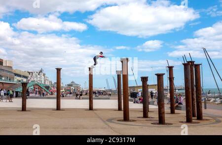 Brighton UK 28. Juli 2020 - EIN Freerunner springt an einem hellen und sonnigen, aber luftigen Tag über die Golden Spiral Pillars an der Küste von Brighton. Das Wetter wird in den nächsten Tagen im Südosten heiß, mit Temperaturen, die in einigen Gebieten über 30 Grad erreichen werden: Credit Simon Dack / Alamy Live News Stockfoto