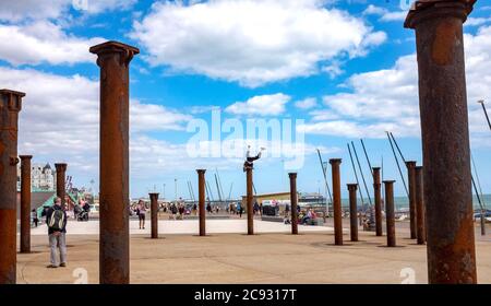 Brighton UK 28. Juli 2020 - EIN Freerunner springt an einem hellen und sonnigen, aber luftigen Tag über die Golden Spiral Pillars an der Küste von Brighton. Das Wetter wird in den nächsten Tagen im Südosten heiß, mit Temperaturen, die in einigen Gebieten über 30 Grad erreichen werden: Credit Simon Dack / Alamy Live News Stockfoto