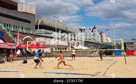 Brighton UK 28. Juli 2020 - Beachvolleyball-Spieler genießen den sonnigen Nachmittag an der Strandpromenade von Brighton. Das Wetter wird in den nächsten Tagen im Südosten heiß, mit Temperaturen, die in einigen Gebieten über 30 Grad erreichen werden: Credit Simon Dack / Alamy Live News Stockfoto