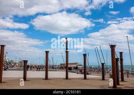 Brighton UK 28. Juli 2020 - EIN Freerunner springt an einem hellen und sonnigen, aber luftigen Tag über die Golden Spiral Pillars an der Küste von Brighton. Das Wetter wird in den nächsten Tagen im Südosten heiß, mit Temperaturen, die in einigen Gebieten über 30 Grad erreichen werden: Credit Simon Dack / Alamy Live News Stockfoto