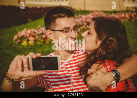 Glücklich schönes Paar unter Selfie auf Handy, Umarmung und Spaß zusammen Stockfoto