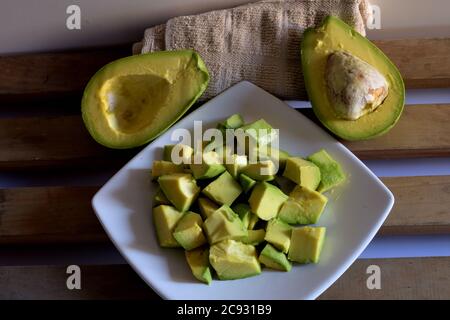 High-Angle-Aufnahme von aufgeschnittenen Avocado-Stücken auf einem Teller Mit halbierten Avocados Stockfoto