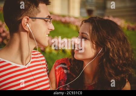 Nahaufnahme eines glücklichen jungen Paares, das Spaß im Park hat, während man Musik hört Stockfoto