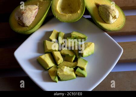 High-Angle-Aufnahme von aufgeschnittenen Avocado-Stücken auf einem Teller Mit halbierten Avocados Stockfoto