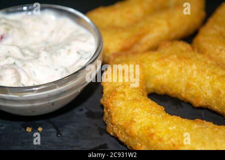 Zwiebelringe und ein Glas-Topf mit Sauce. Nahaufnahme Stockfoto