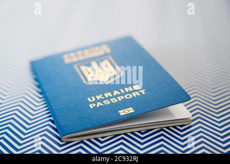 Nahaufnahme des neuen ukrainischen blauen internationalen biometrischen Passes mit Identifikations-Chip auf weißem und blauem Hintergrund. Selektiver Fokus Stockfoto