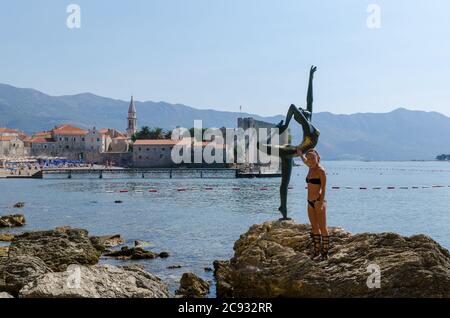 Tourist posiert für ein Foto in der Nähe der Statue Stockfoto