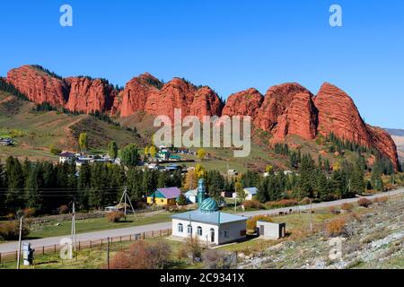 Djety-Oguz Tal und Schlucht in Issyk-Kul Region in Kirgisistan. Kleine Moschee mit rotem Sandstein Felsen bekannt als die Seven Bulls Rock dahinter. Jeti Oguz. Stockfoto