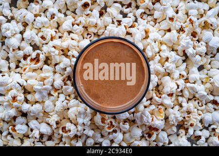 Draufsicht auf eine Tasse Tee im Hintergrund von hausgemachten Popcorns platziert. Hausgemachter Snack. Stockfoto