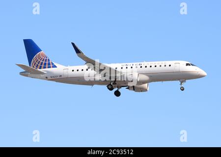 United Express Embraer ERJ-175 wird von SkyWest Airlines bei der endgültigen Annäherung an LAX vor blauem Himmel betrieben. Regionales Verkehrsflugzeug registriert als N142SY. Stockfoto