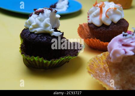 Nahaufnahme von niedlichen Cupcakes mit einem gebissenen Schokolade ein Stockfoto