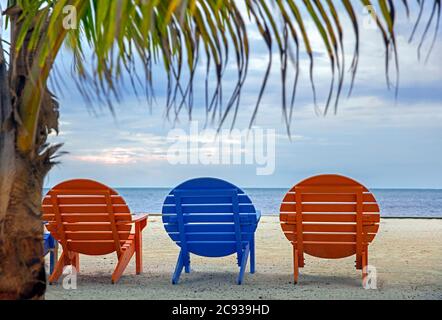 Bunte runde Holzliegen im Ferienort Caye Caulker / Cayo Caulker, Koralleninsel vor der Küste von Belize in der Karibik Stockfoto