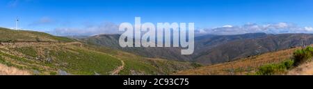 Ultra Panoramablick auf die Pisao Berge, mit Windturbinen und blauen Himmel als Hintergrund, in Portugal Stockfoto