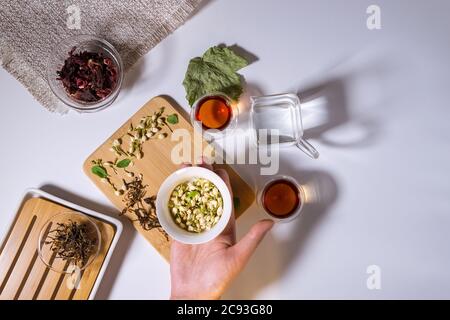 Chinesische Teeparty. Trockene Granulate verschiedener Teesorten. Flatlay, Draufsicht. Kräutertee, auf weißem Hintergrund Stockfoto