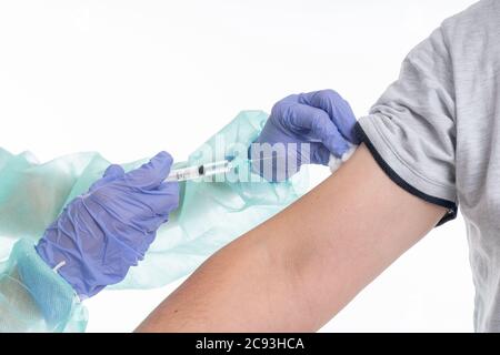 Junge Ärztin trägt eine schützende medizinische Uniform tun ein Injektion an einen Covid-19-Patienten Stockfoto