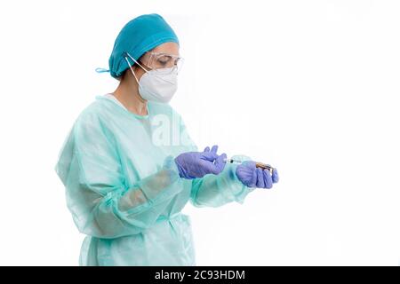 Junge Ärztin trägt eine schützende medizinische Uniform tun ein Injektion an einen Covid-19-Patienten Stockfoto