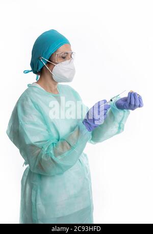 Junge Ärztin trägt eine schützende medizinische Uniform tun ein Injektion an einen Covid-19-Patienten Stockfoto