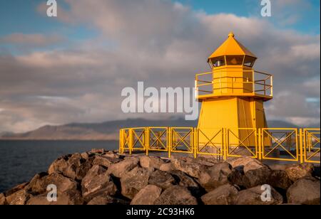 Low-Angle-Aufnahme eines gelben Leuchtturms, aufgenommen auf einem wolkiger Tag Stockfoto