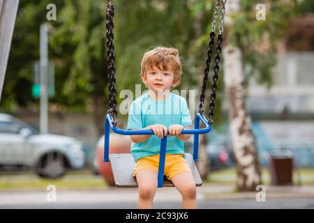 Kleiner Junge von zwei Jahren spielt im Sommer in einer Kinderstadt. Kinderlebensstil Stockfoto