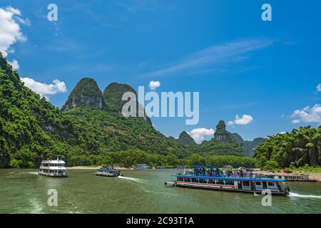 Yangshuo, China - August 2019 : Verkehr von Sightseeing-Booten mit Touristen Segeln zwischen atemberaubenden Karst Berglandschaft auf dem herrlichen Li riv Stockfoto