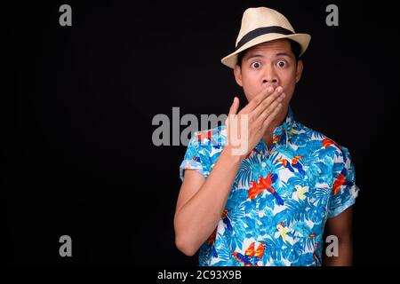 Junge asiatische Tourist Mann bereit für Urlaub vor schwarzem Hintergrund Stockfoto