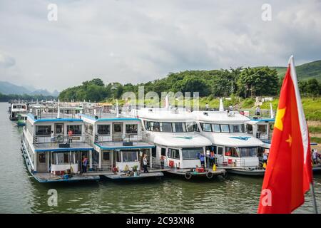 Guilin, China - August 2019 : Besichtigungsboote warten auf Touristen am Flussufer des prächtigen Li Flusses Stockfoto