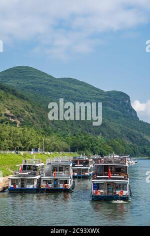 Guilin, China - August 2019: Sightseeing Boote warten auf Touristen am Ufer des herrlichen Li-fluss in Guilin Stockfoto