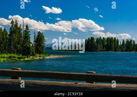 Yellowstone ein Fluss, wie er Lake Yellowstone mit Bergen im Hintergrund verlässt, wie von der Fishing Bridge im Yellowstone National Park gesehen Stockfoto