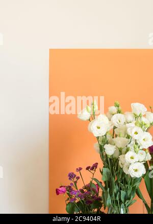 Schöne Blumen in Vasen auf Orange Stockfoto