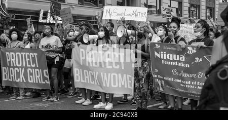 Black Womens/Womxn March Black Lives Matter - Schützen Sie schwarze Frauen und Mädchen Banner am Times Square Protest Stockfoto