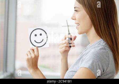 Hört auf zu rauchen, Frau schneidet eine Zigarette mit einer Schere Stockfoto