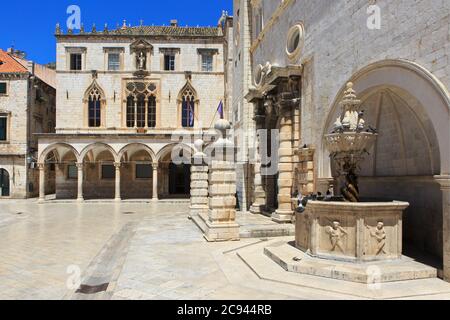 Der Sponza Palast (1516-1522) und der kleine Onofrio Brunnen (1440-1442) am Luza Platz in der Altstadt von Dubrovnik, Kroatien Stockfoto