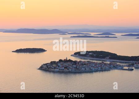 Panoramablick über die malerische Insel Primosten (Gespanschaft Sibenik-Knin), Kroatien und die umliegenden Inseln bei Sonnenuntergang Stockfoto