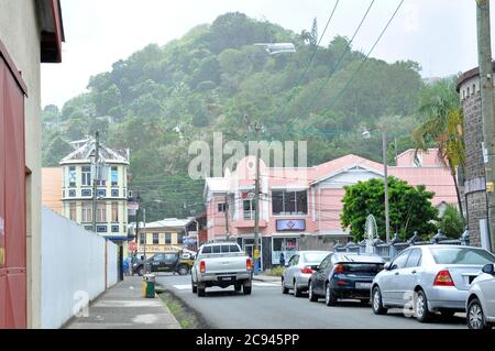 Regnerisches Wetter in St. Lucia. Blick auf die Straße, Auto geparkt und Wald auf einem Hügel im Hintergrund mit Nebel bedeckt. Stockfoto