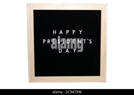 Ein schwarzes Schild mit einem Birkenrahmen, der Happy Presidents Day in weißen Buchstaben auf einem rein weißen Hintergrund sagt Stockfoto