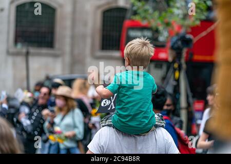 LONDON, ENGLAND - 28. JULI 2020: Ein kleiner Junge Fan winkt einen Jolly Roger Schädel und Kreuzknochen Flagge vor dem Royal Court of Justice in der Johnny Depp Stockfoto