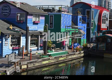 Ein Arbeiter trägt eine Leiter an einem schwimmenden Souvenirladen vorbei und schwimmt in Fisherman’s Wharf in Victoria, British Columbia, Kanada auf Vancouver Island. Fi Stockfoto