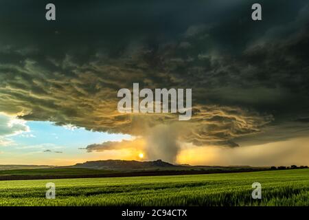 Panorama eines massiven Mesocyclone Wetter supercell, die eine Pre-Tornado-Bühne ist, passiert einen grasbewachsenen Teil der Great Plains, während heftig versuchen Stockfoto