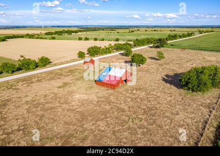 Eine verlassene alte Scheune mit dem Symbol von Texas auf dem Dach befindet sich in einem ländlichen Gebiet des Staates, eingerahmt von Ackerland. Stockfoto