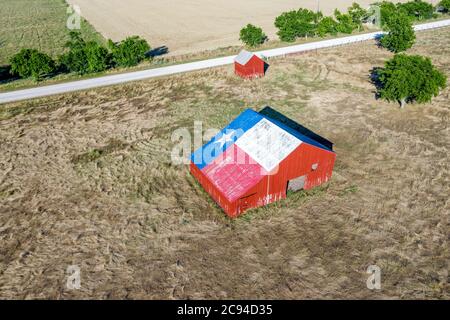 Eine verlassene alte Scheune mit dem Symbol von Texas auf dem Dach befindet sich in einem ländlichen Gebiet des Staates, eingerahmt von Ackerland. Stockfoto