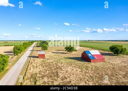 Eine verlassene alte Scheune mit dem Symbol von Texas auf dem Dach befindet sich in einem ländlichen Gebiet des Staates, eingerahmt von Ackerland. Stockfoto