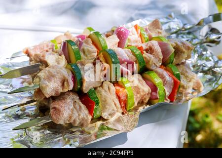 Schweinshash-Kebab mit Zwiebeln, Paprika und Zucchini auf Eisenspießen. Grillgerichte. Stockfoto