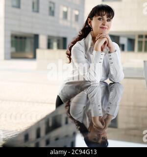 Reife Geschäftsfrau Lächelnd Und Blick Auf Kamera Im Freien Stockfoto