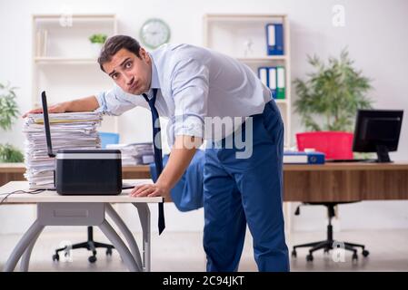 Junge Mitarbeiter von Kopien beim Kopieren von Maschine Stockfoto