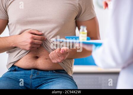 Männlicher Diabetiker, der einen jungen Arzt besucht Stockfoto