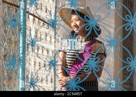 Sagaing/Myanmar - 2. Oktober 2019: Eine burmesische Frau in Nationalkostüm steht und lächelt einen Touristen in einem alten Tempel an. Stockfoto