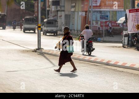 Sagaing/Myanmar-3. Oktober 2019: Ein birmanischer Mönch ging morgens für eine Spende von Nahrung von Buddhisten auf der Straße. Stockfoto